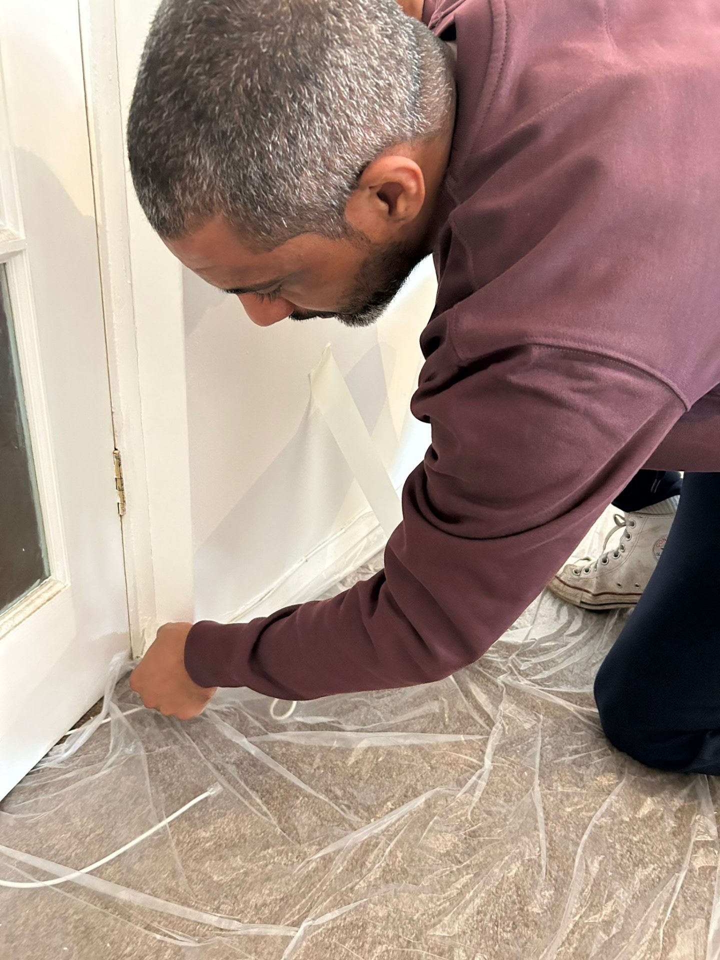 Ricky from OUTTUU masking skirting boards during a Bedford decorating prep