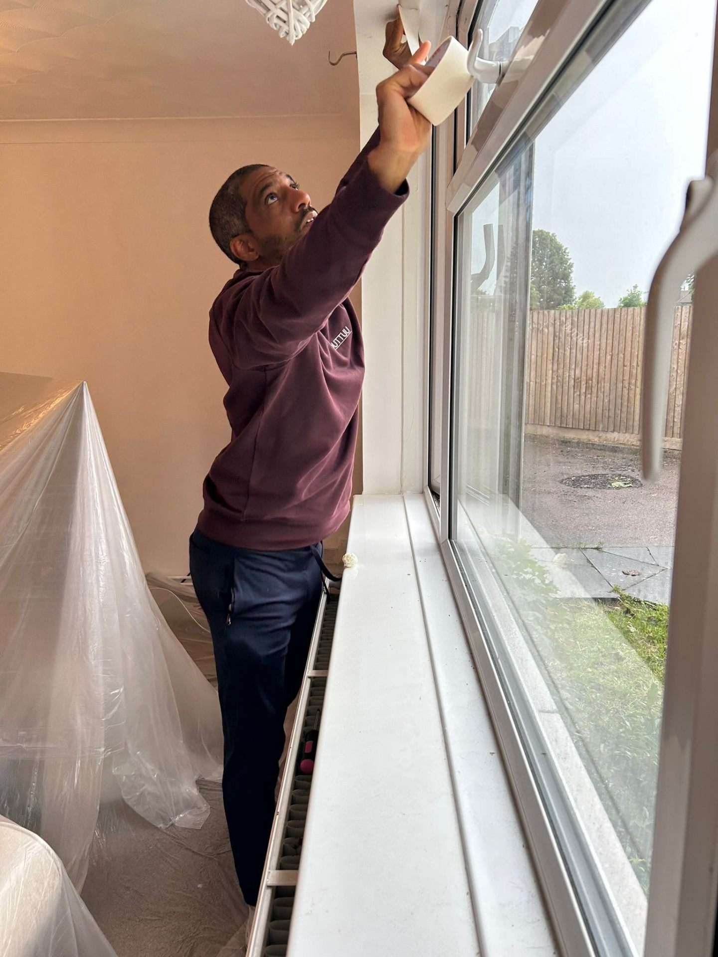 Ricky preparing a room for decorating in Bedford wearing OUTTUU branded workwear