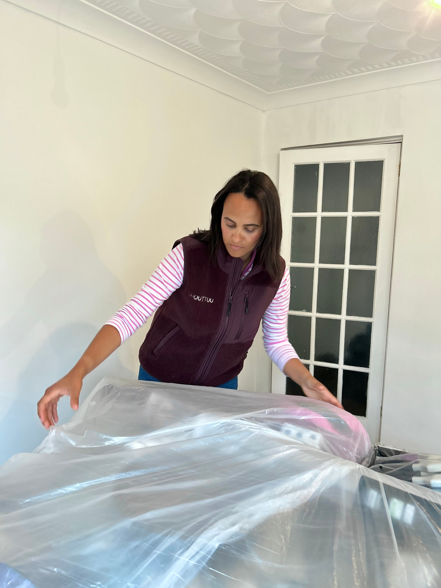 Christina protecting furniture during decorating preparation in Bedfordshire.