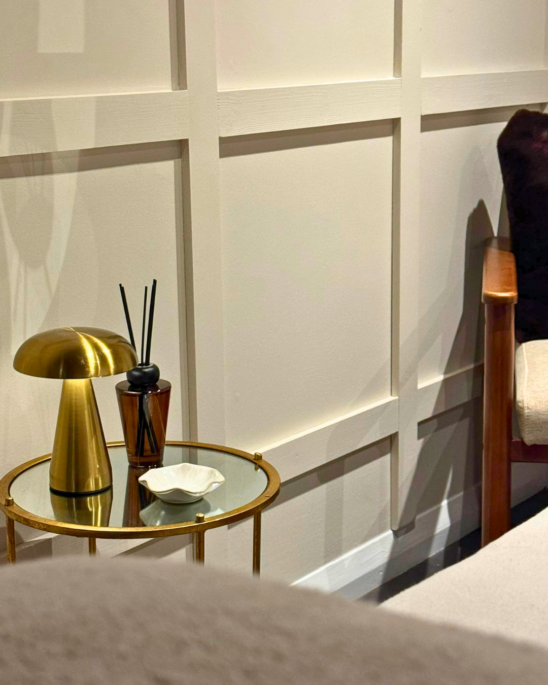 Refreshed commercial salon interior in Bedford with cream wall panelling, brass accents and soft lighting.
